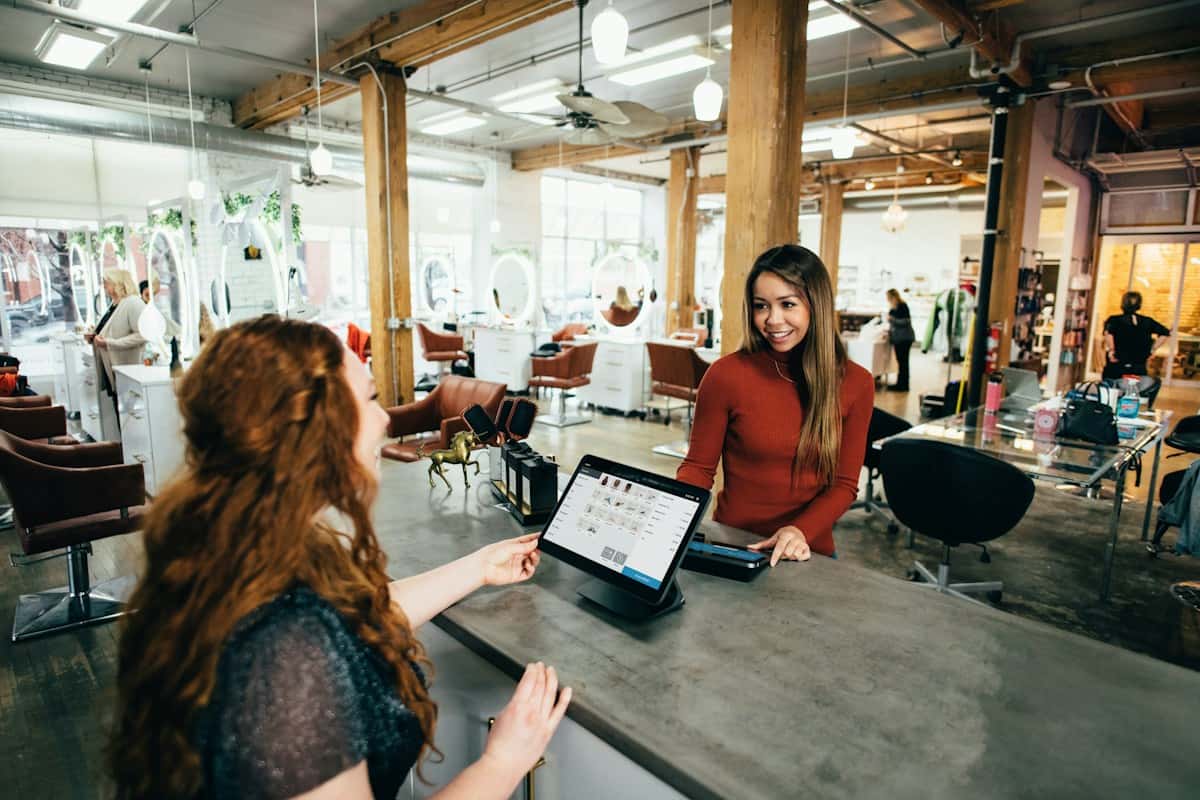 A salon receptionist checking out a customer at the front desk